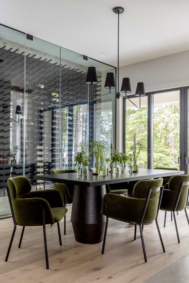 natural hardwood flooring in dining room of lake house with wine rack and green velvet chairs